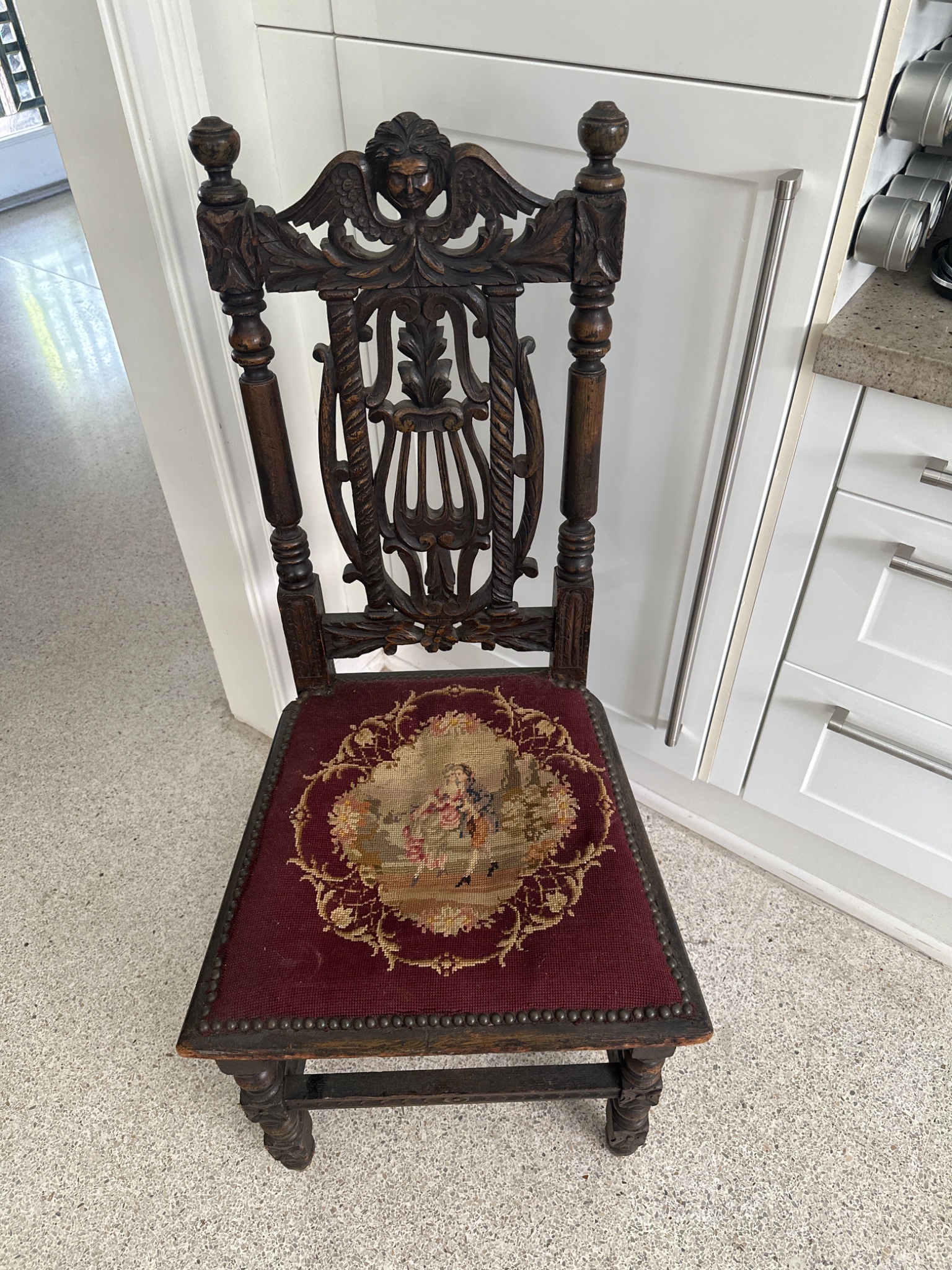 Carved wooden side chair with needlepoint seat