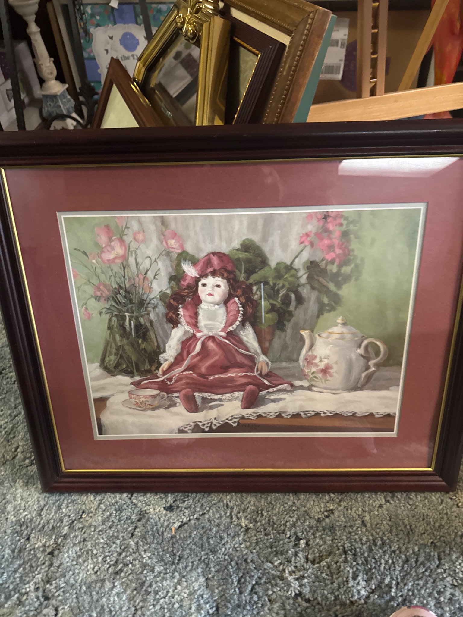 Framed decorative print or painting of a porcelain doll with teapot still life