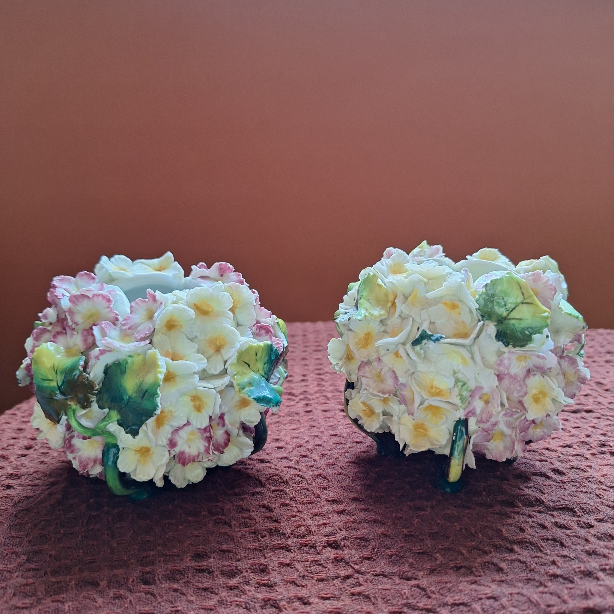 Pair of porcelain floral decorative objects (likely small trinket boxes, scent bottles, or ornamental containers)